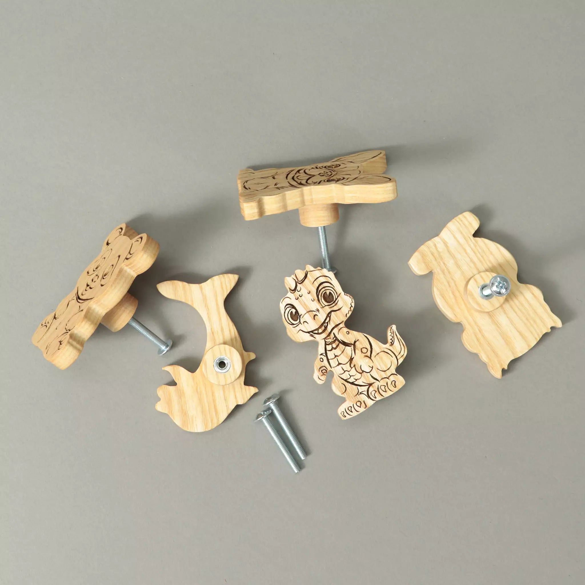 Knobs in solid ash lying on a grey background with the mounting screws