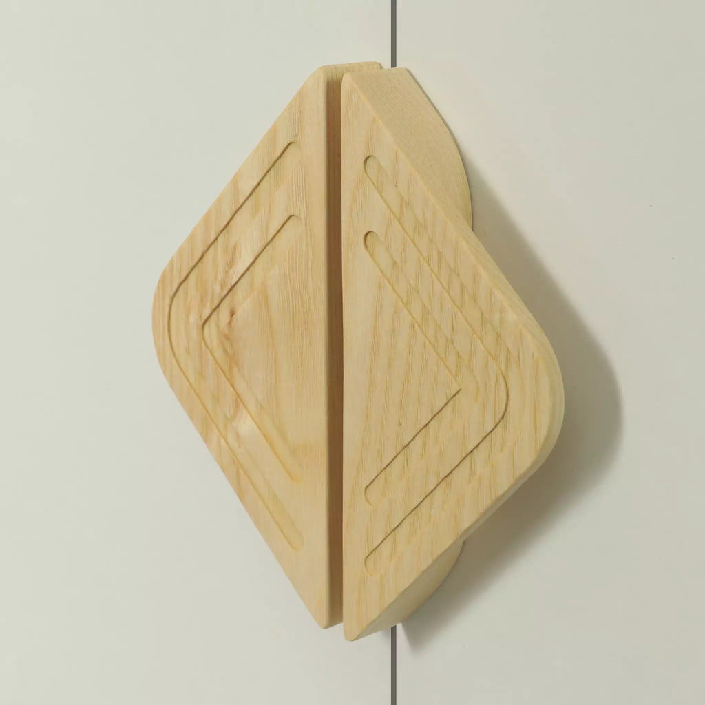Twin line diamond cabinet pull in solid ash fitted across two doors, both grooves closing across the join