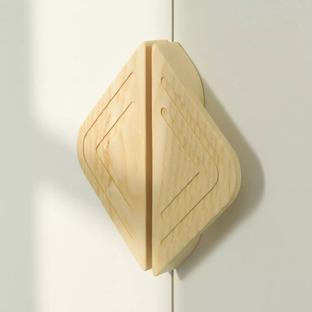 Twin line diamond cabinet pull in solid ash on a pale cabinet, lit from the side to show both grooves