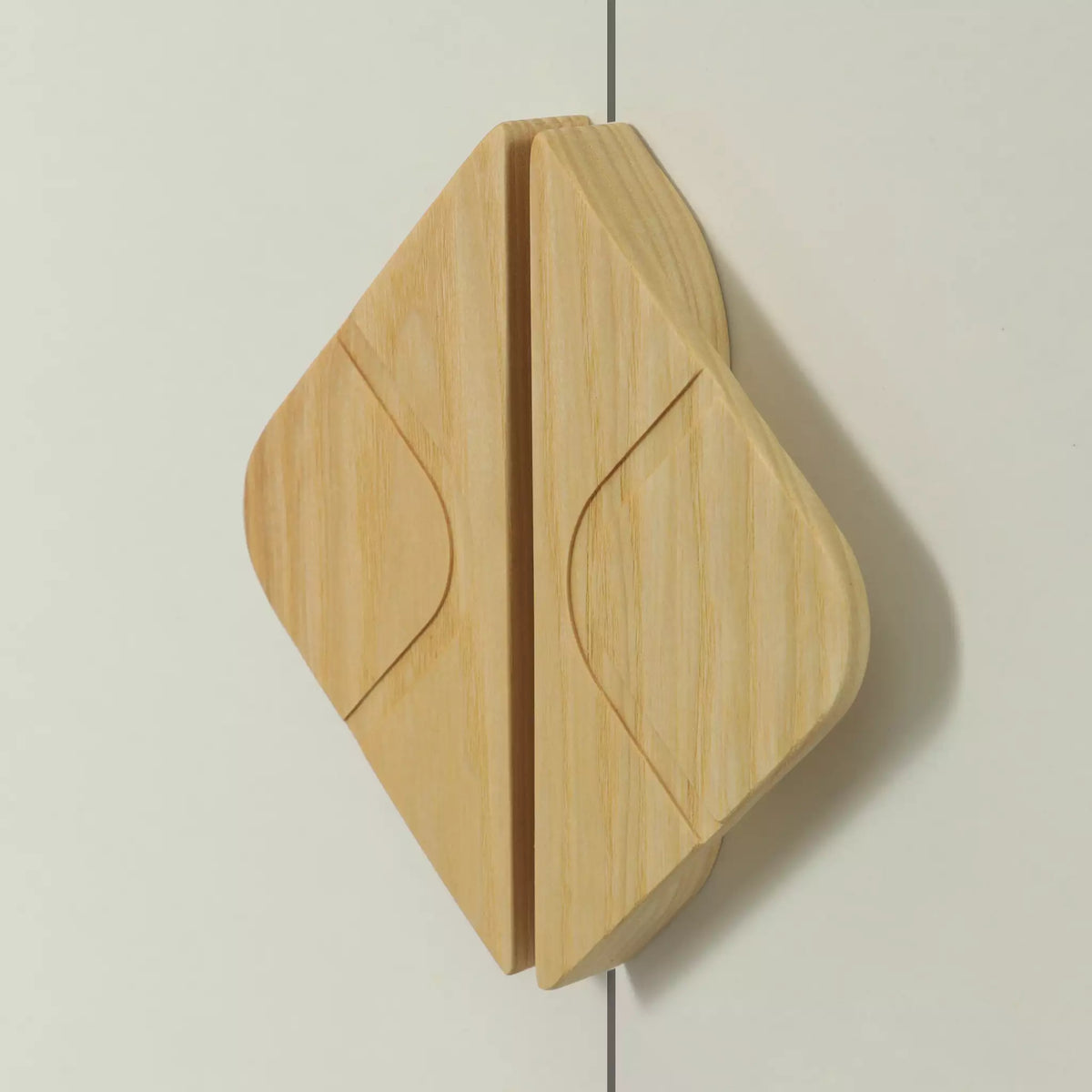 Leaf diamond cabinet pull in solid ash fitted across two doors, the two halves of the leaf meeting at the join