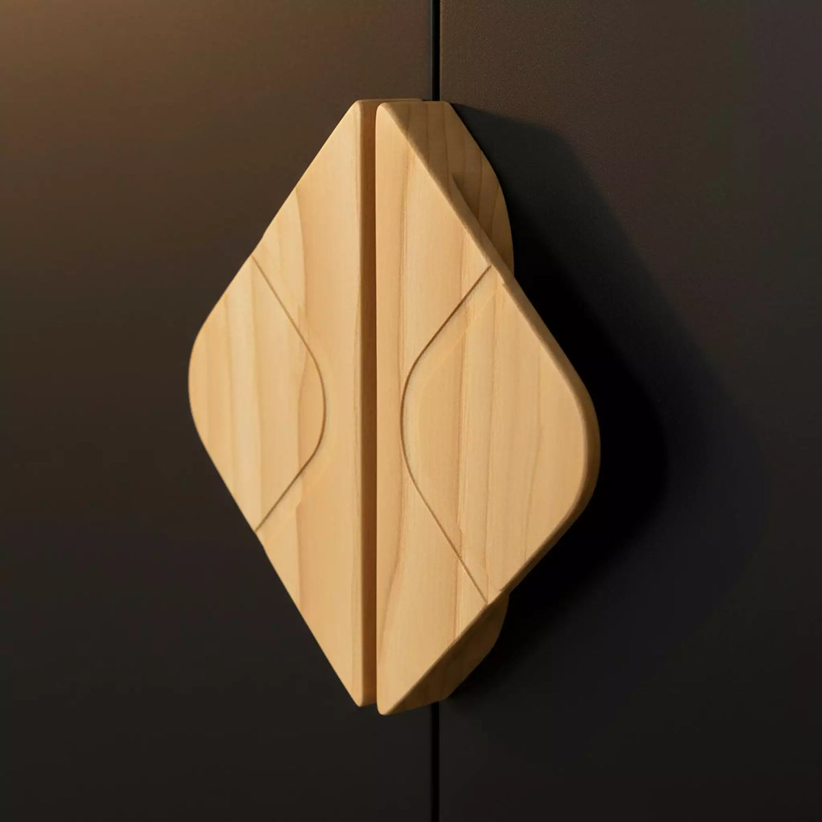 Leaf diamond cabinet pull in solid ash on a pale cabinet, lit from the side to show the carved leaf