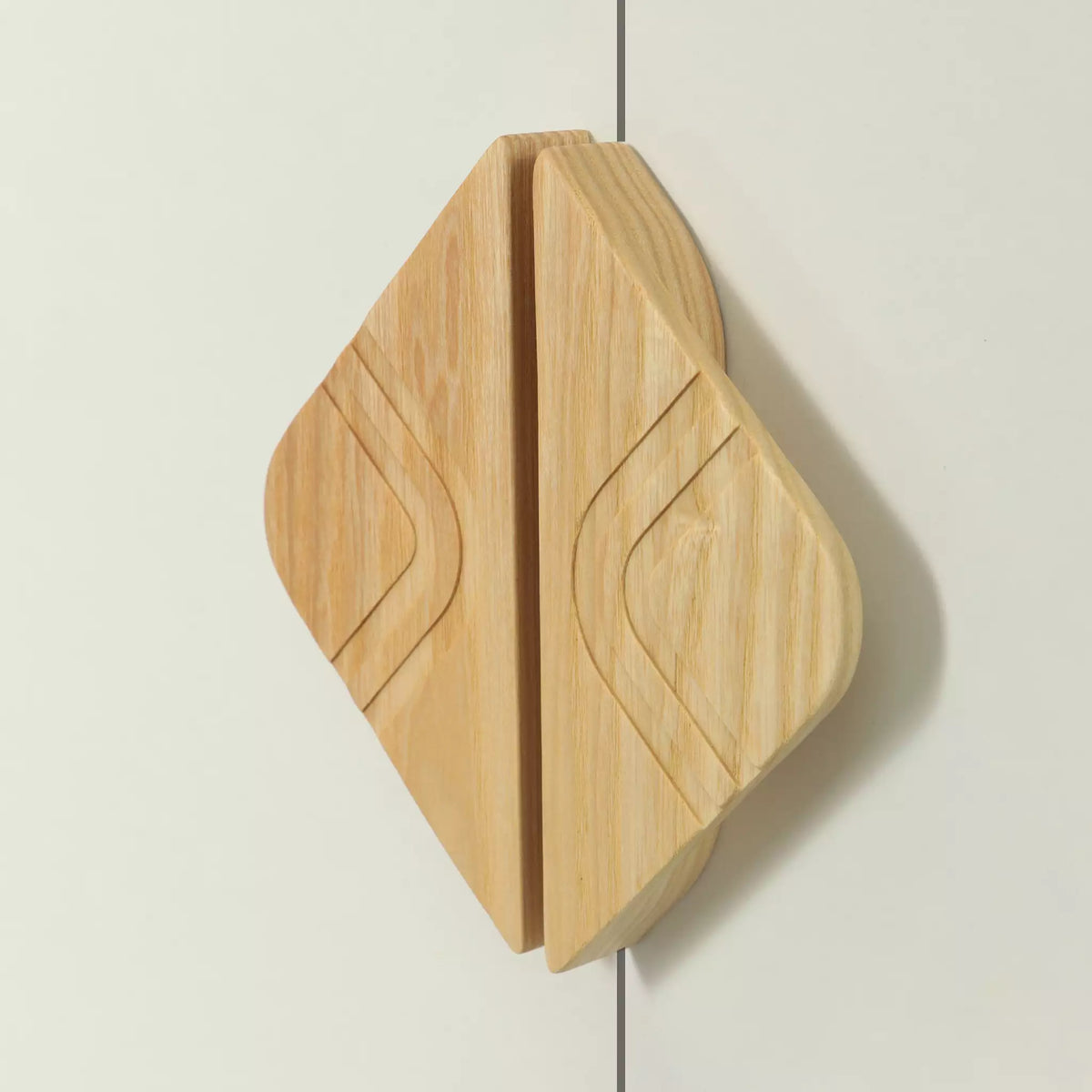 Arch diamond cabinet pull in solid ash fitted across two doors, the arches mirroring each other at the join