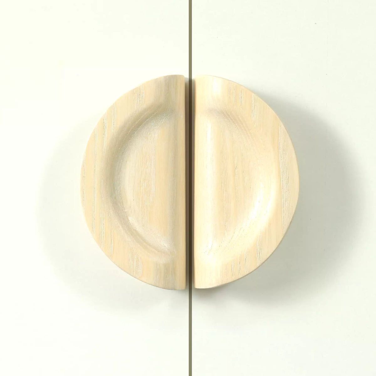 Dish cabinet pull in solid ash seen straight on, the two hollowed halves closing into a circle