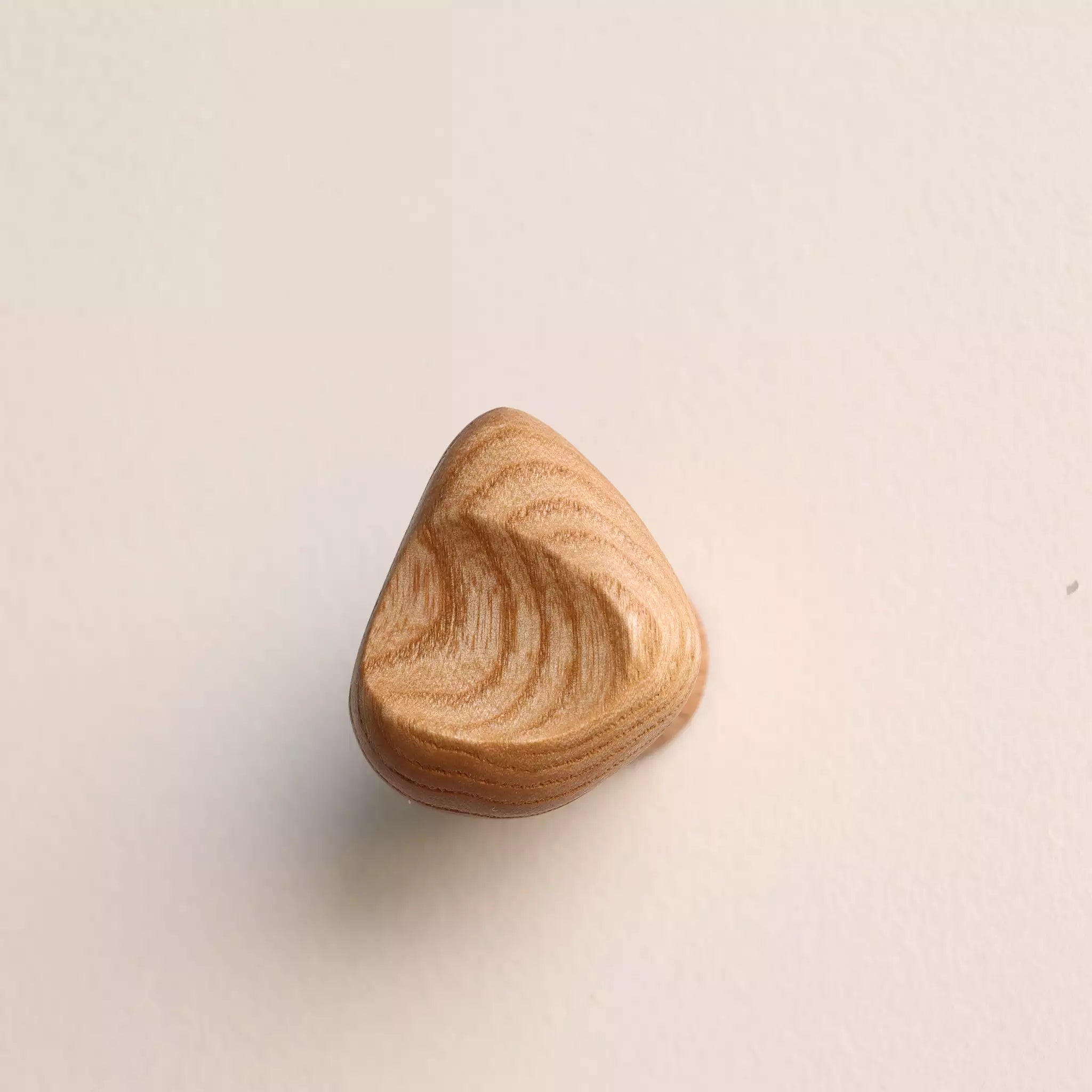 Shell hook in the natural finish, mounted on a wall and seen from the side
