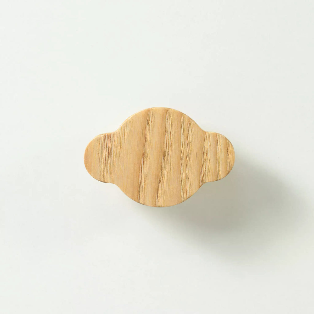 Cloud-shaped ash cabinet knob in bare wood, seen face on