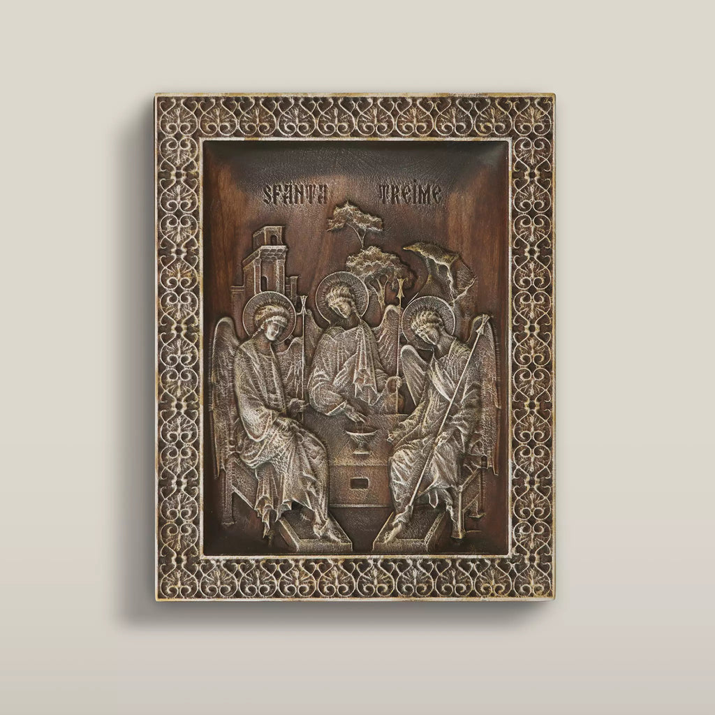Carved wooden icon of the Holy Trinity after Rublev, three angels seated around a table, within a pierced lattice border