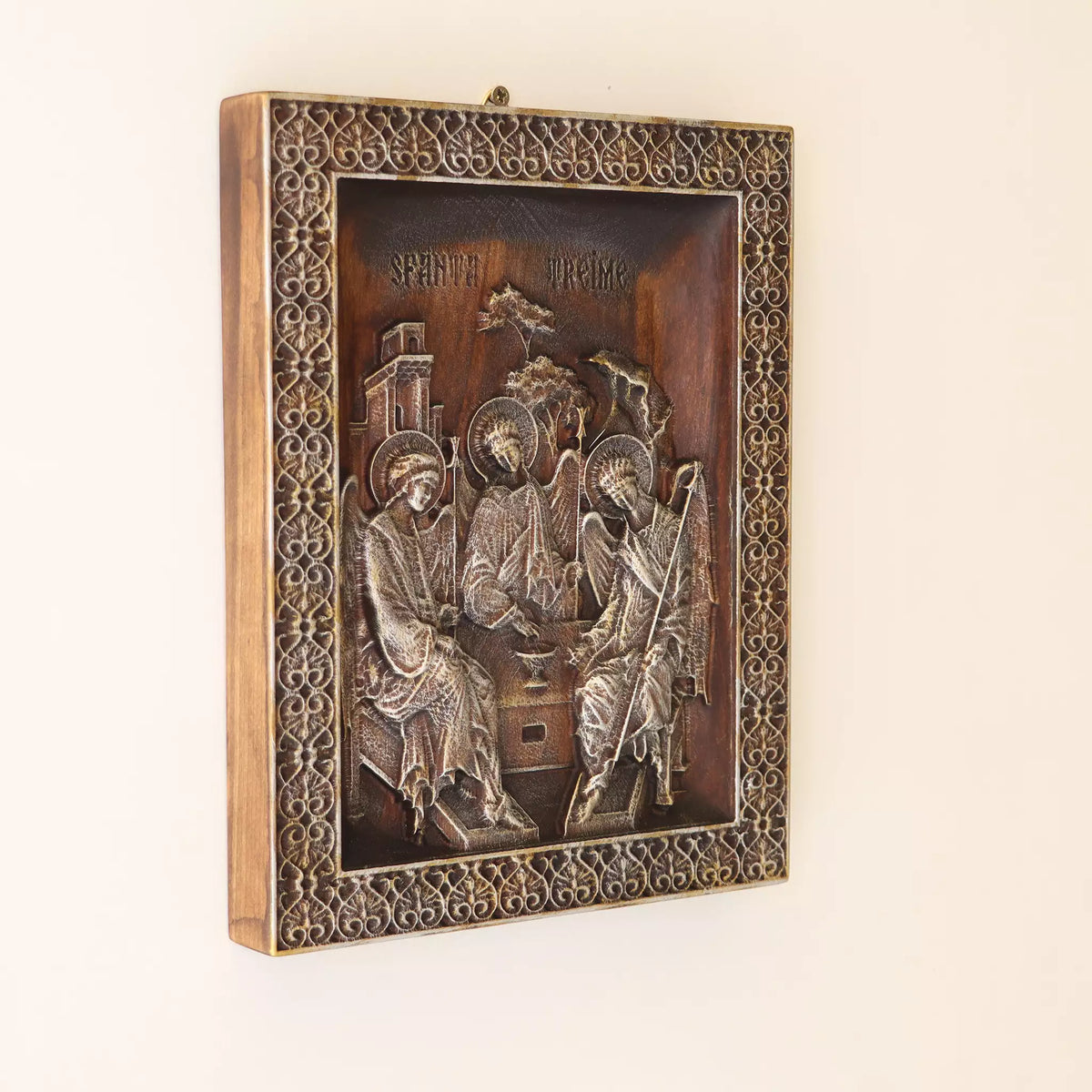 The icon seen at an angle on a pale wall, showing the depth of the pierced frame