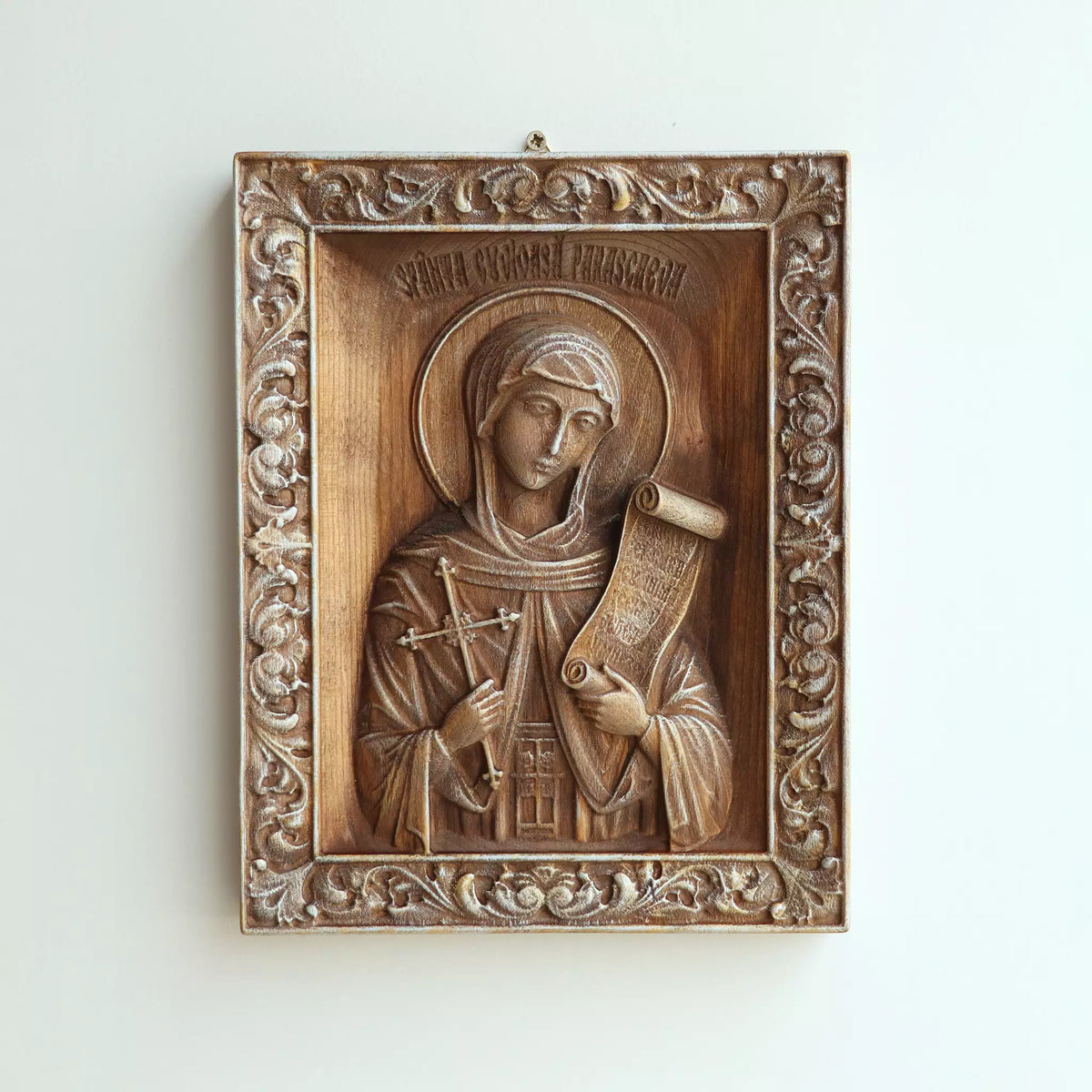 The icon hanging flat on a wall, with the metal hanger visible at the top