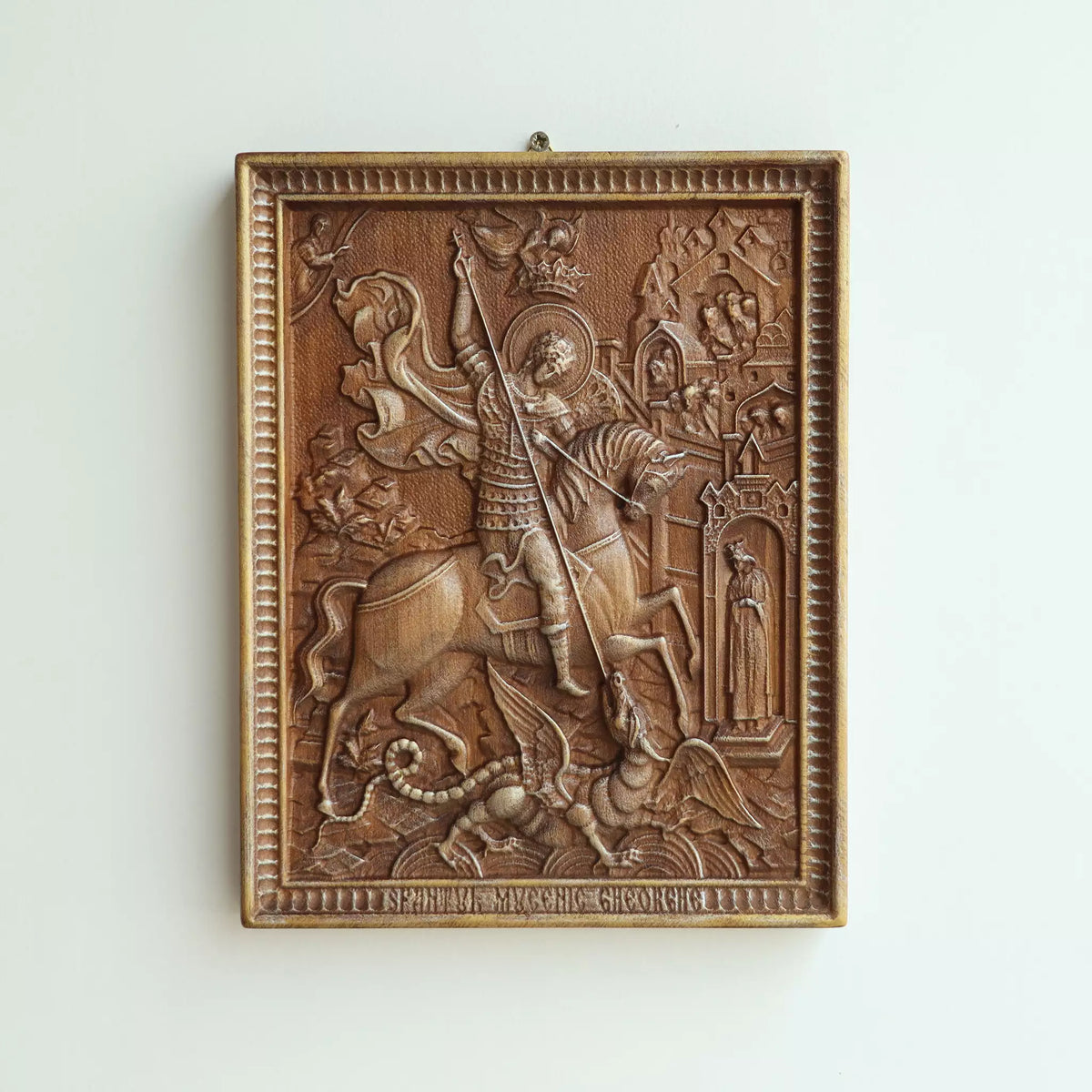 The icon hanging flat on a wall, with the metal hanger visible at the top
