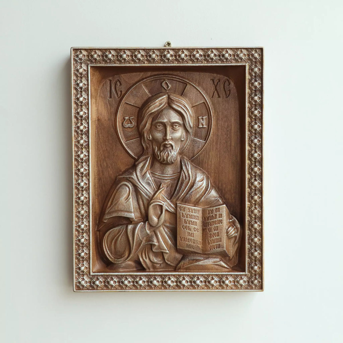 The icon hanging flat on a wall, with the metal hanger visible at the top