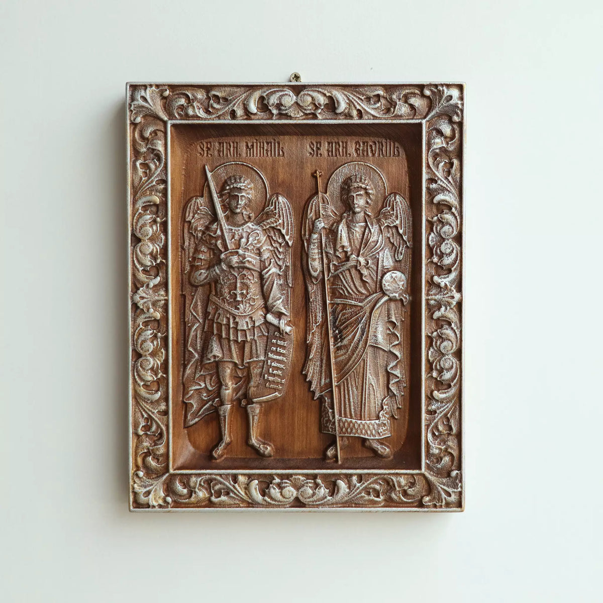 The icon hanging flat on a wall, with the metal hanger visible at the top