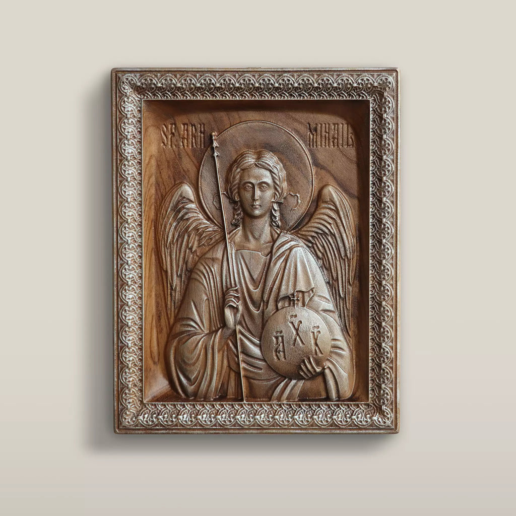Carved wood icon of the Archangel Michael hanging on a pale wall, seen from the front