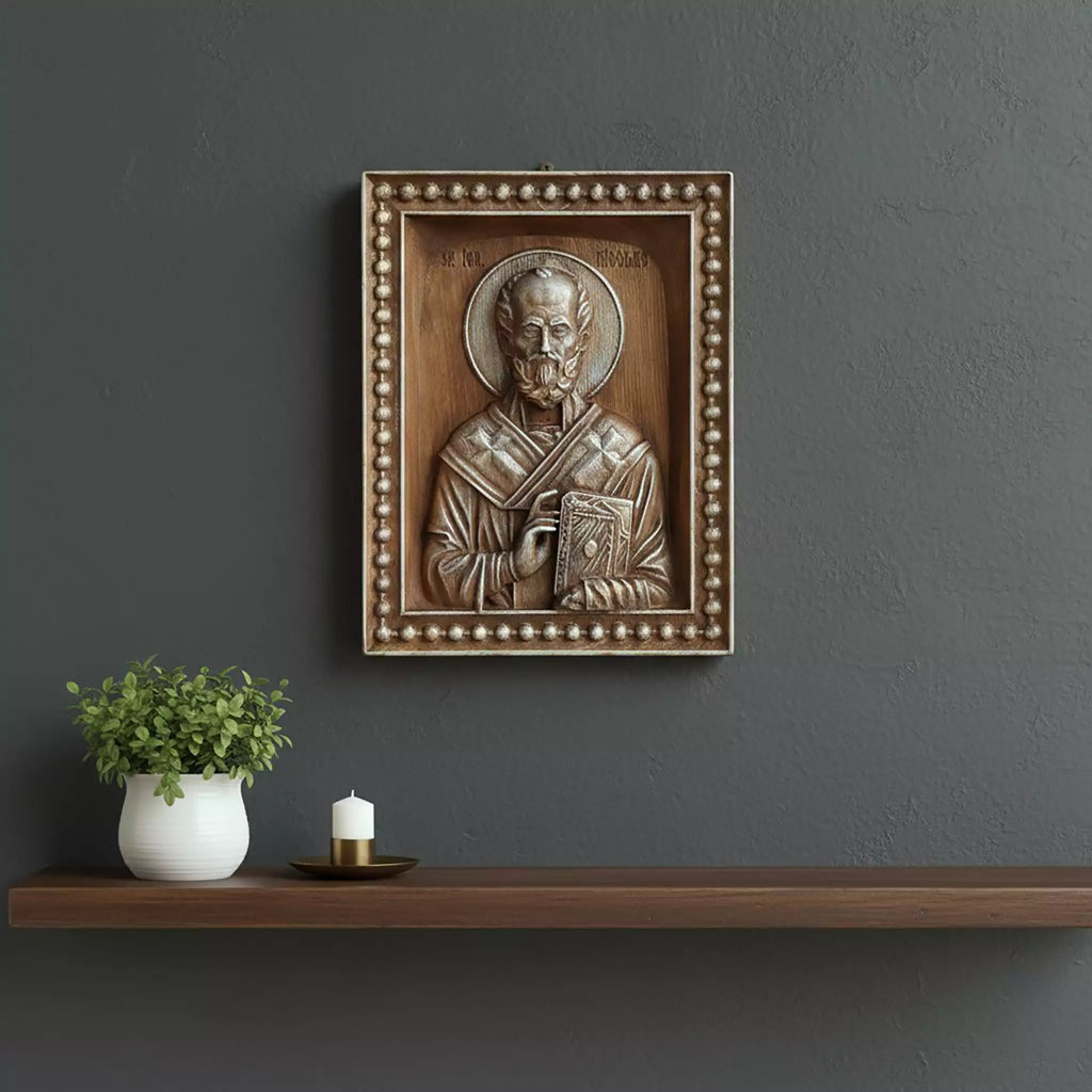 The icon hung on a dark grey wall above a floating shelf with a plant and a candle