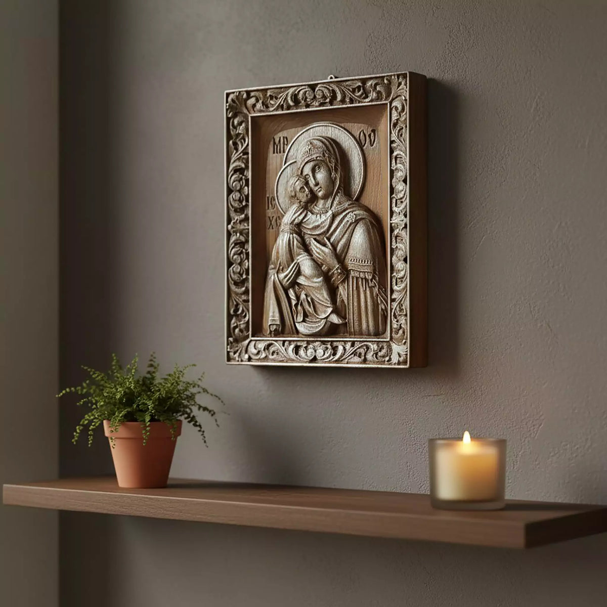 The icon hung on a dark grey wall above a floating shelf with a plant and a candle