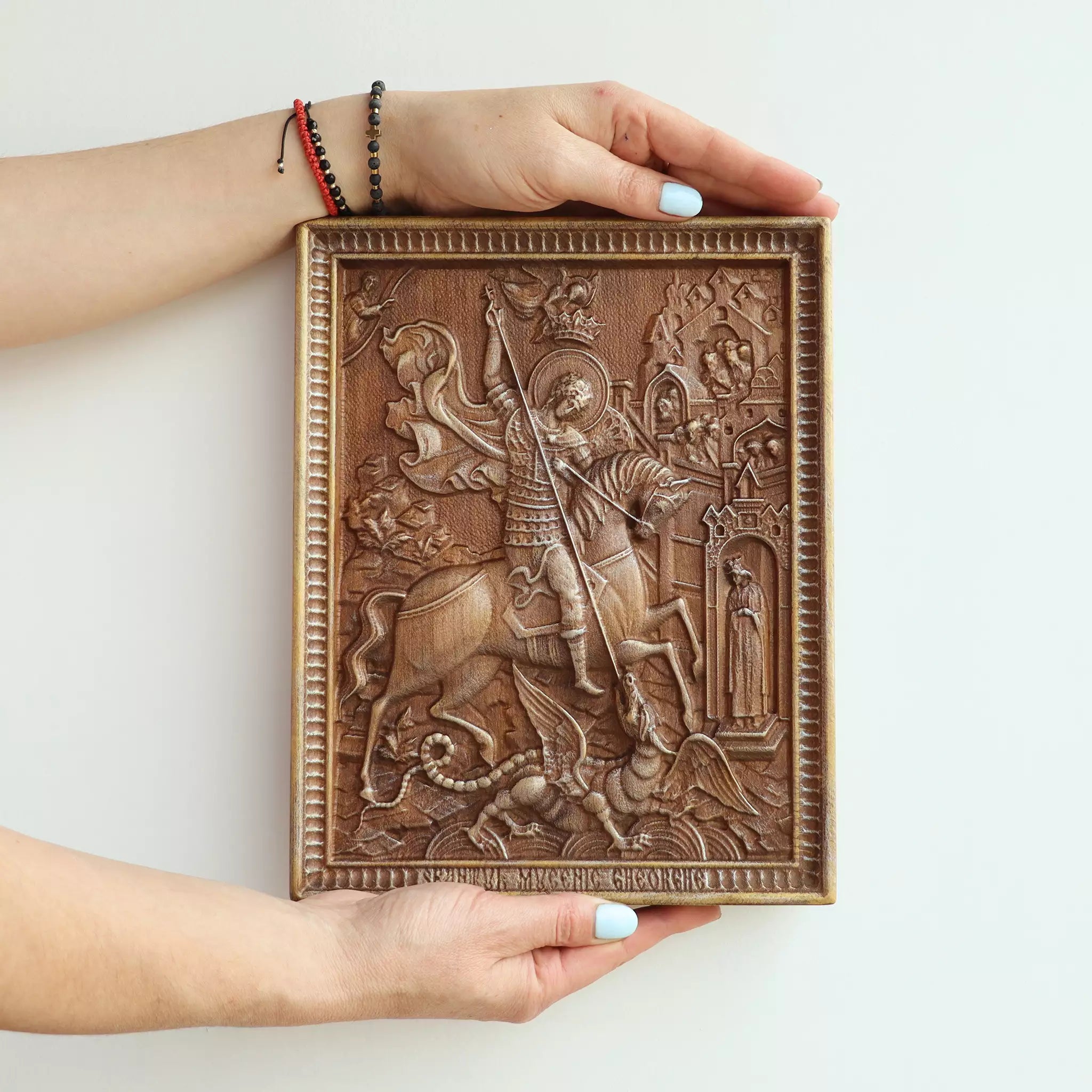 Two hands holding the icon, showing its size against an adult's hands