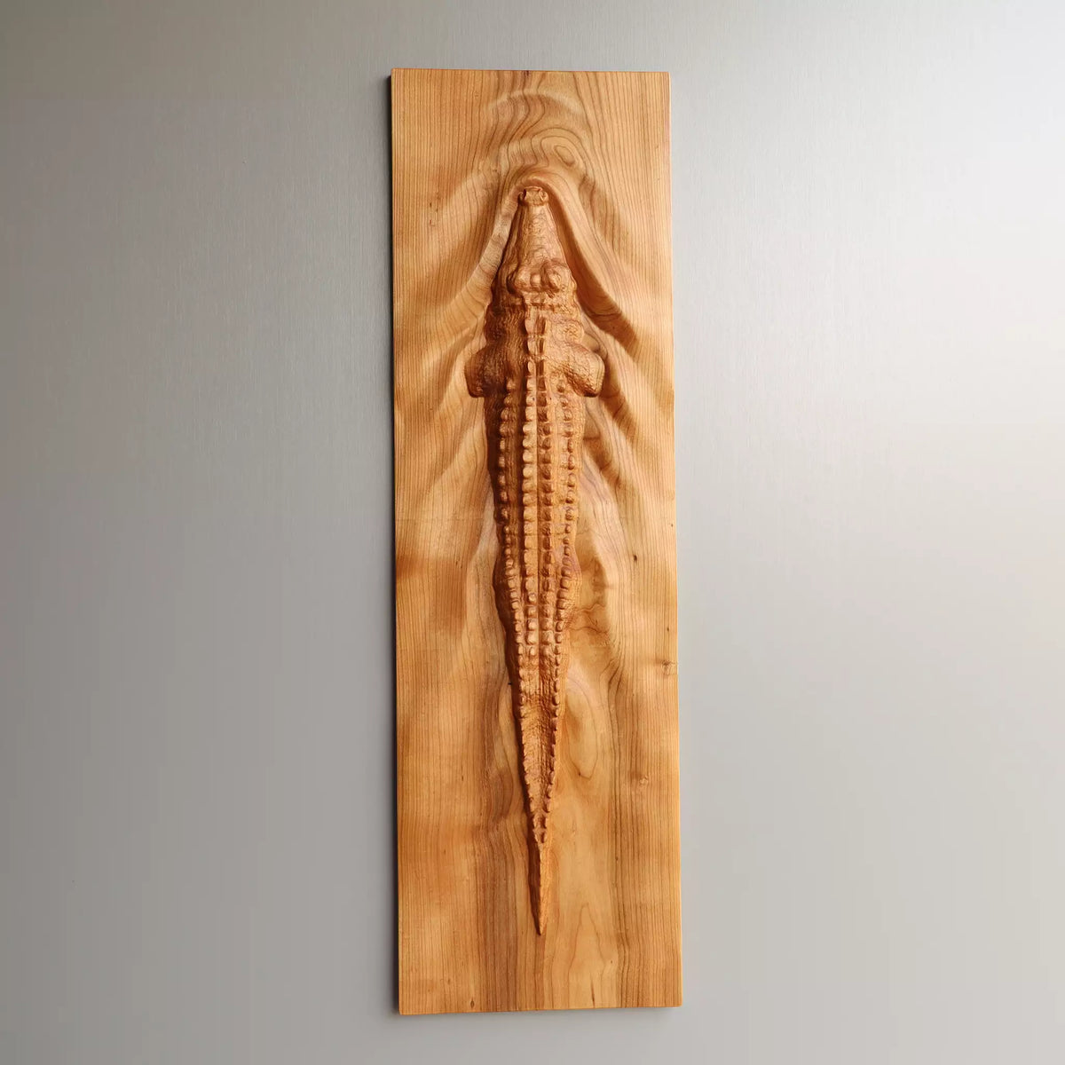 The panel hung vertically on a pale wall, the whole crocodile visible