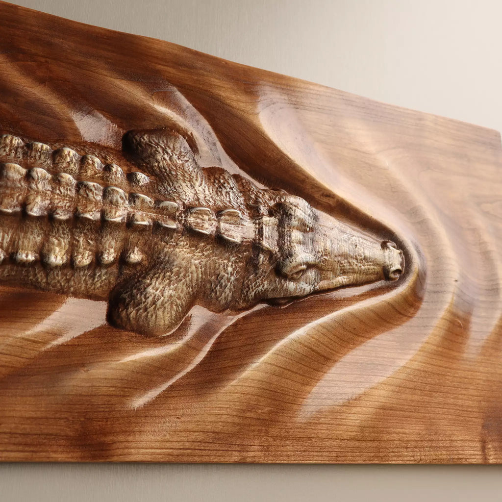 Close view of the crocodile's head carved in relief, with the wake spreading out around it