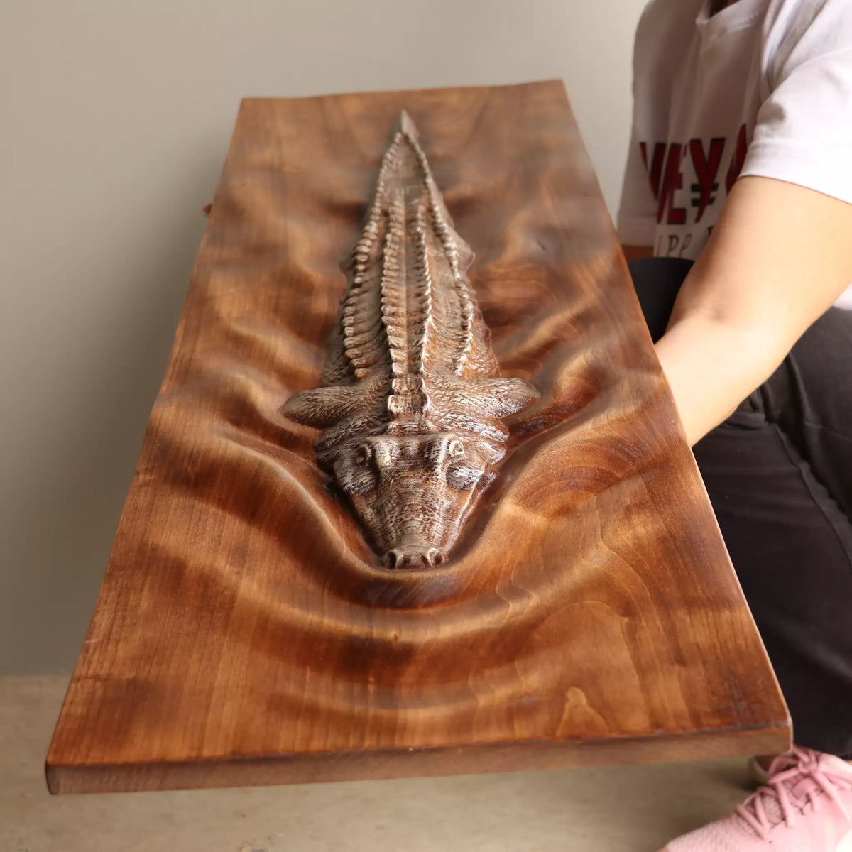 The panel laid flat with a person beside it, showing the length of the carving