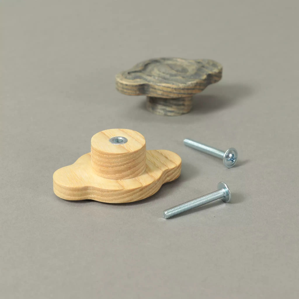 Back of an unfinished petal cabinet knob showing the base and the threaded metal insert, with a Dark Gray knob and the mounting hardware behind