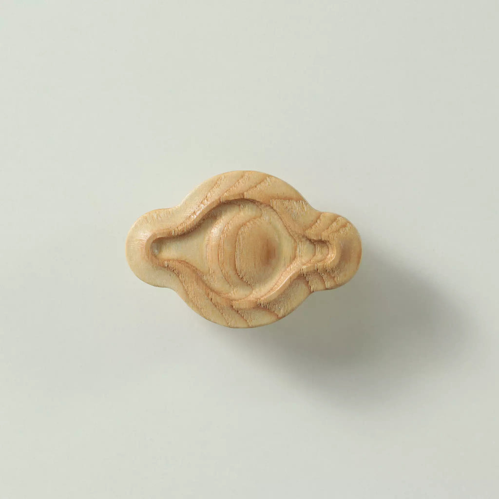 Unfinished solid ash petal cabinet knob seen from the front, showing the domed centre and the carved groove