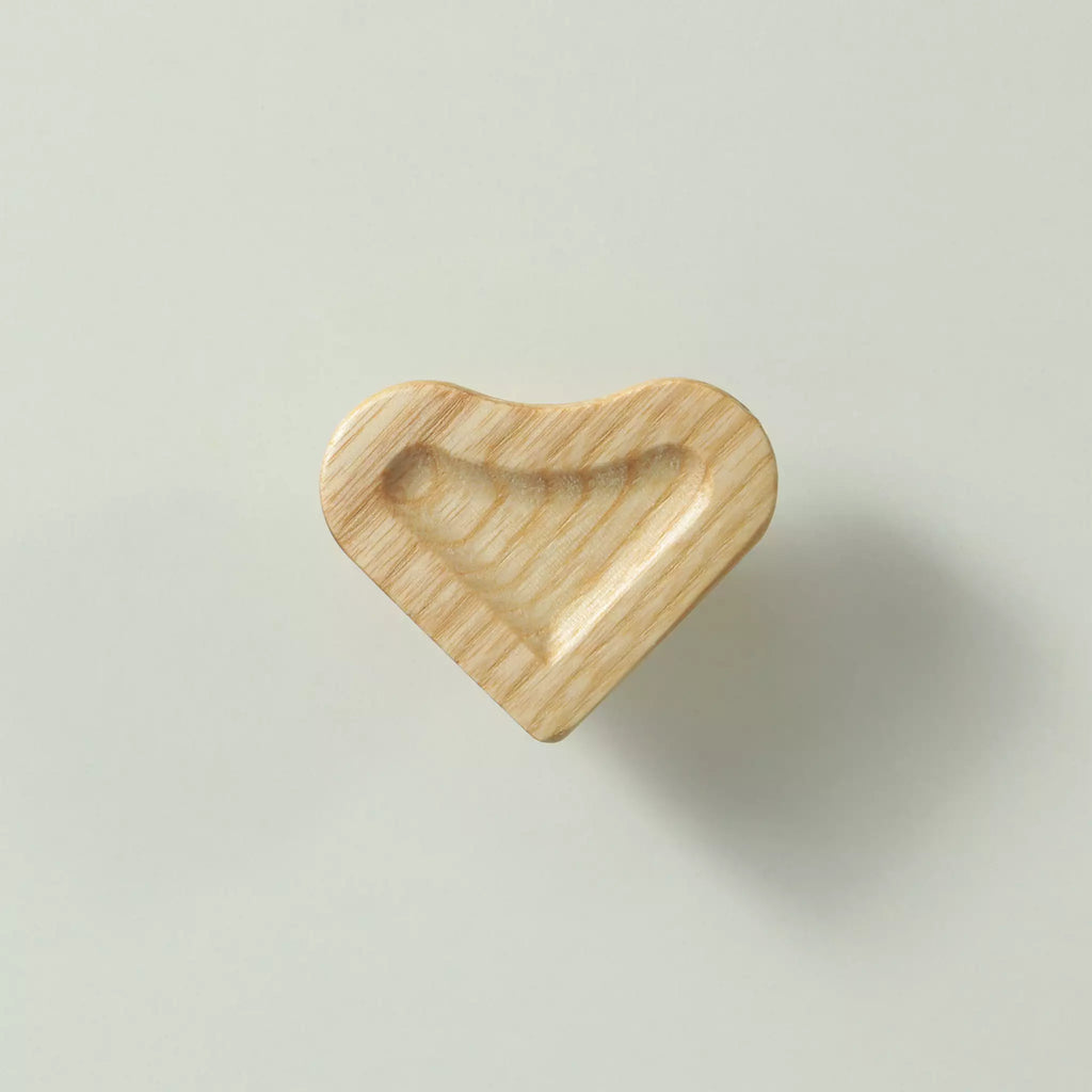 Unfinished solid ash scooped heart cabinet knob seen from the front, showing the deep carved scoop