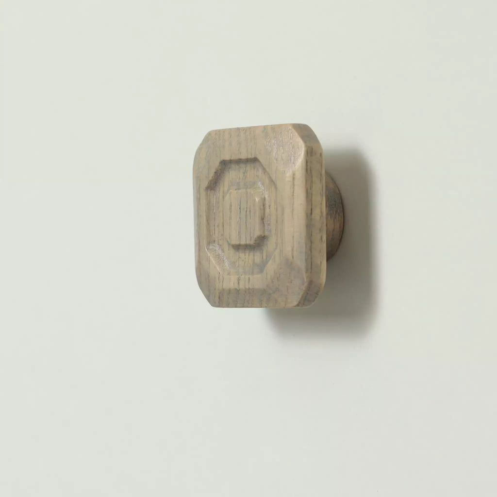 Stepped octagon cabinet knob in the Dark Gray finish seen at an angle, with the base visible behind it