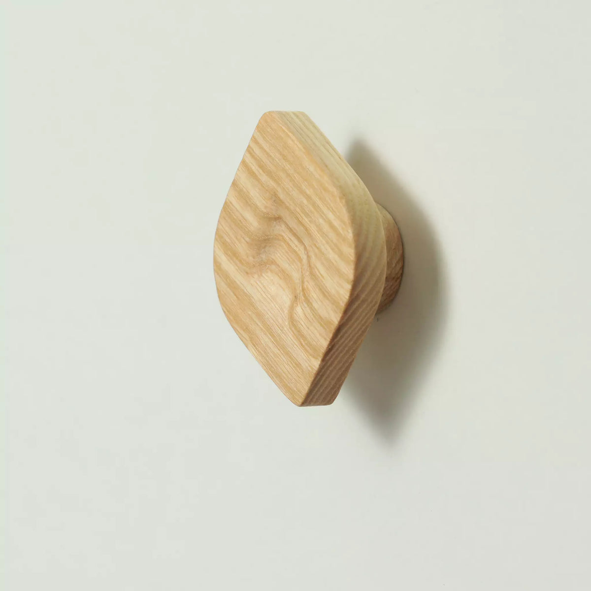 Unfinished solid ash twist cabinet knob seen at an angle from above, showing the two pointed corners