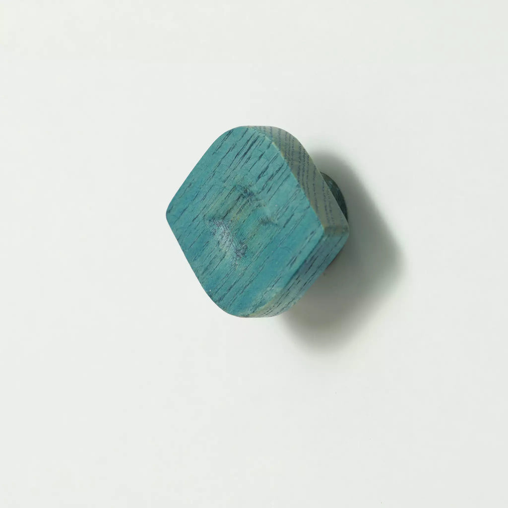Twist cabinet knob in the Blue finish tilted to show the thickness of the block