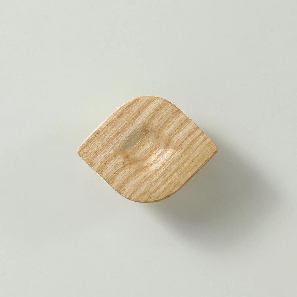 Unfinished solid ash twist cabinet knob seen from the front, showing the carved hollow in the middle