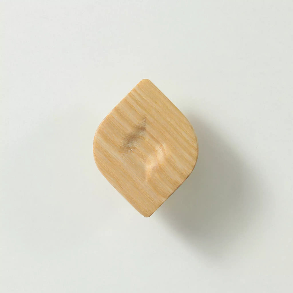 Unfinished solid ash twist cabinet knob seen at an angle, showing the twisted outline