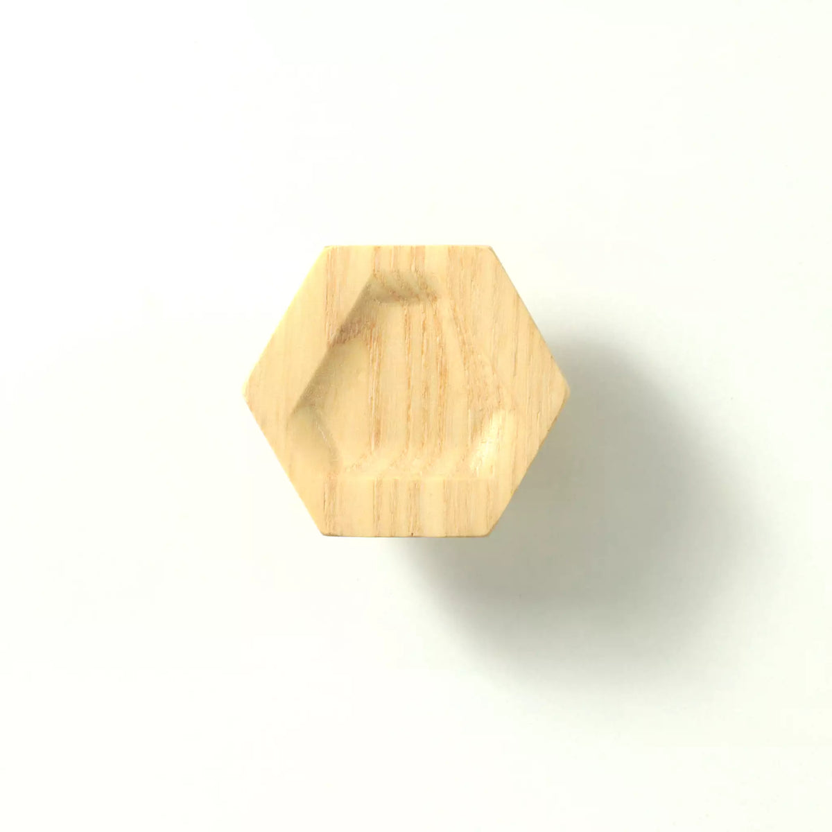 Unfinished solid ash carved hexagon cabinet knob on a white background, showing the triangular hollow