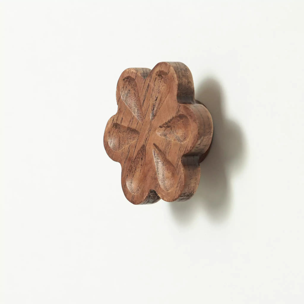 Carved flower cabinet knob in the Walnut finish seen at an angle, with the base visible behind it