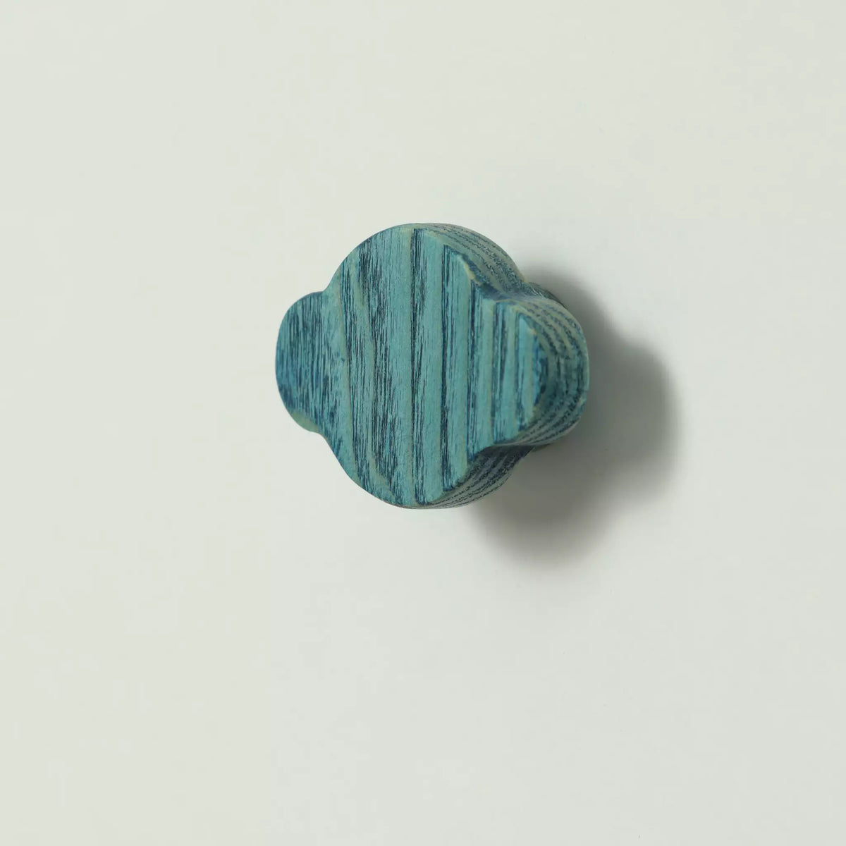 Cloud-shaped ash cabinet knob in bare wood, seen at an angle