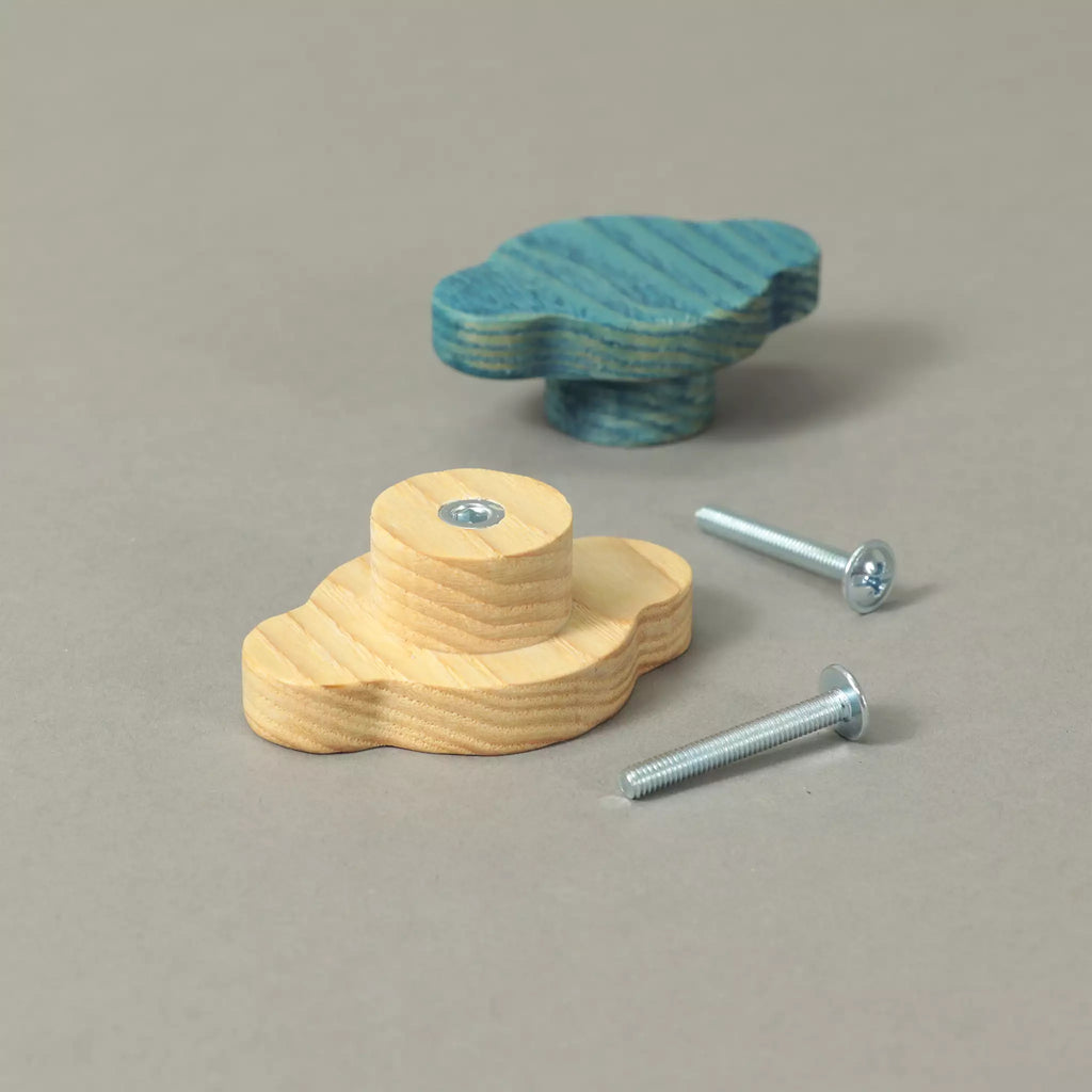 Two cloud-shaped ash cabinet knobs with their mounting screws, one in bare wood and one in Blue