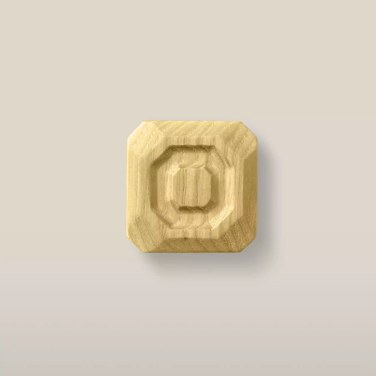 Solid ash stepped octagon cabinet knob in the Cream finish, front view