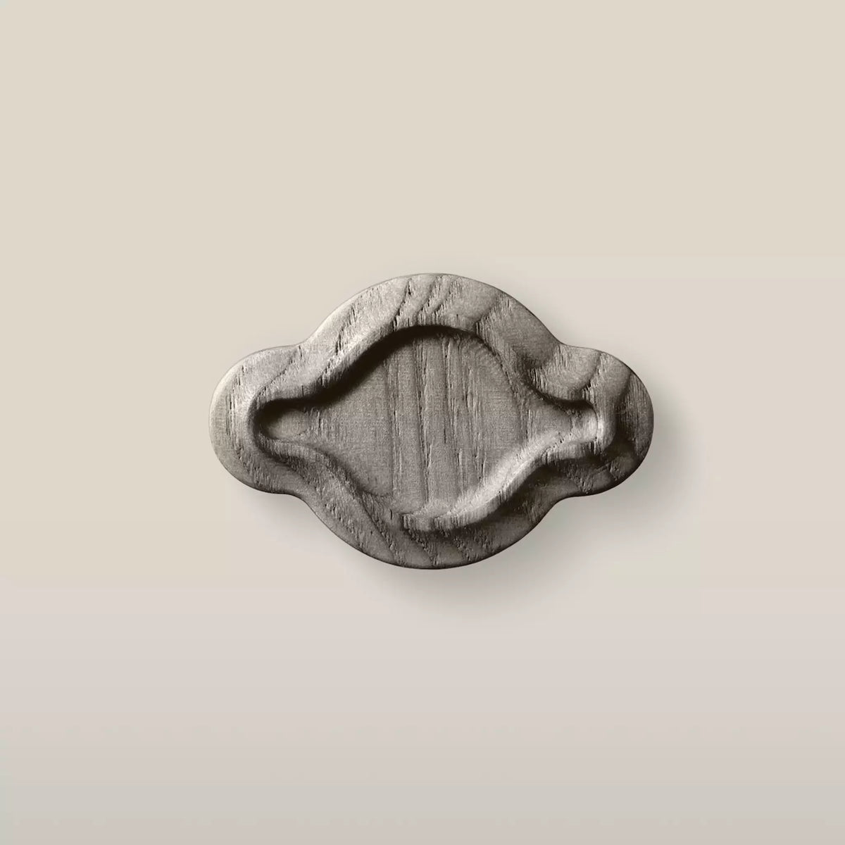 Solid ash scalloped oval cabinet knob in the Dark Gray finish, front view